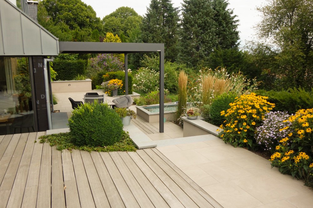 Neu gestaltete Terrasse mit Überdachung und blühenden Beeten